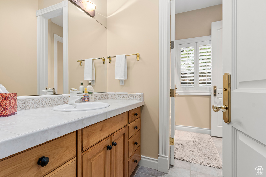 Bathroom featuring tile floors and vanity with extensive cabinet space