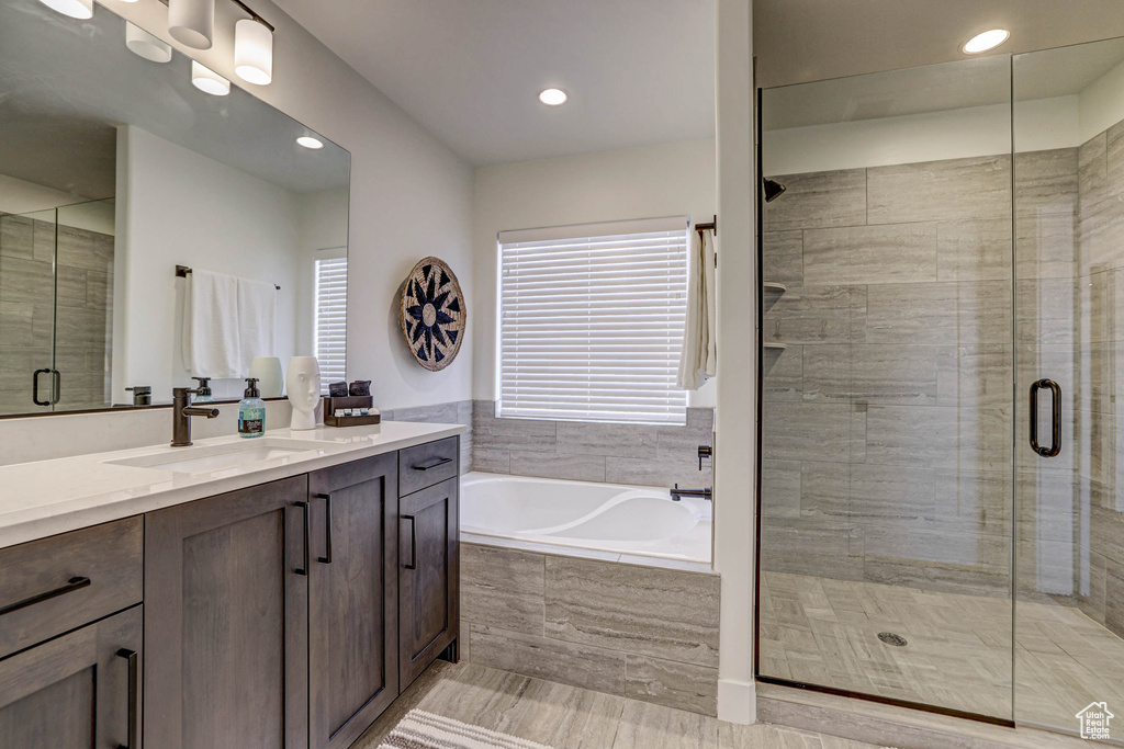 Bathroom featuring tile floors, vanity, and separate shower and tub
