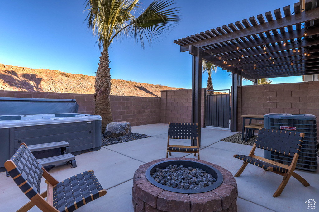 View of terrace featuring central AC, a mountain view, a pergola, a hot tub, and a fire pit