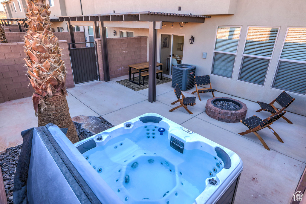 View of terrace featuring a fire pit, an outdoor hot tub, and central AC