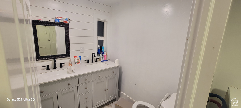 Bathroom featuring toilet and double sink vanity