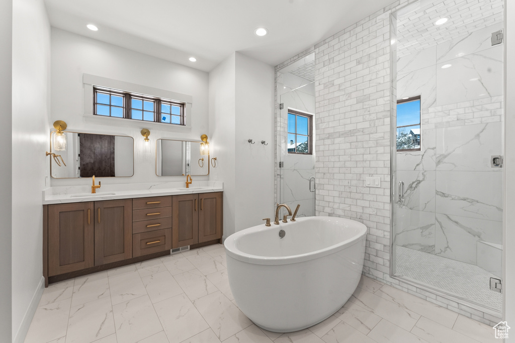 Bathroom featuring tile floors, double sink vanity, and plus walk in shower