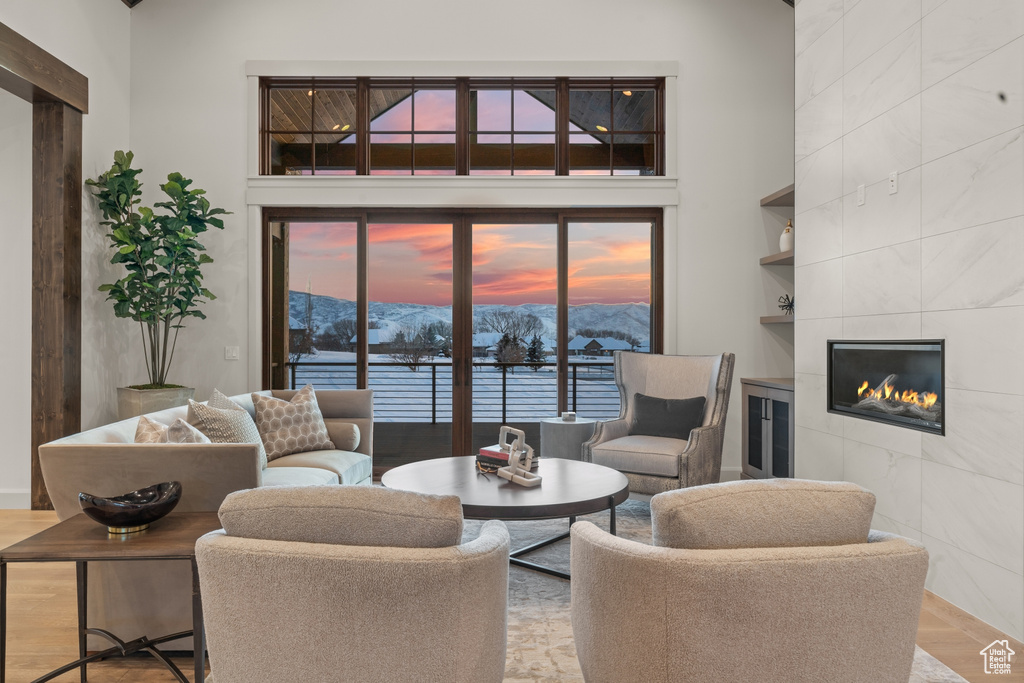 Living room featuring a mountain view, built in shelves, light hardwood / wood-style floors, and a tile fireplace