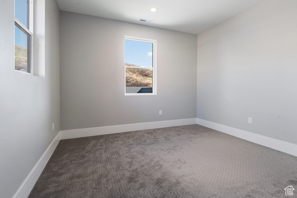 Empty room featuring dark carpet