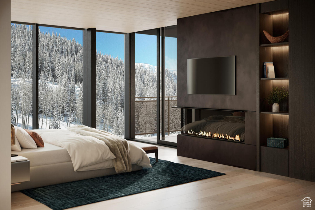 Bedroom with access to exterior, multiple windows, light hardwood / wood-style floors, and floor to ceiling windows