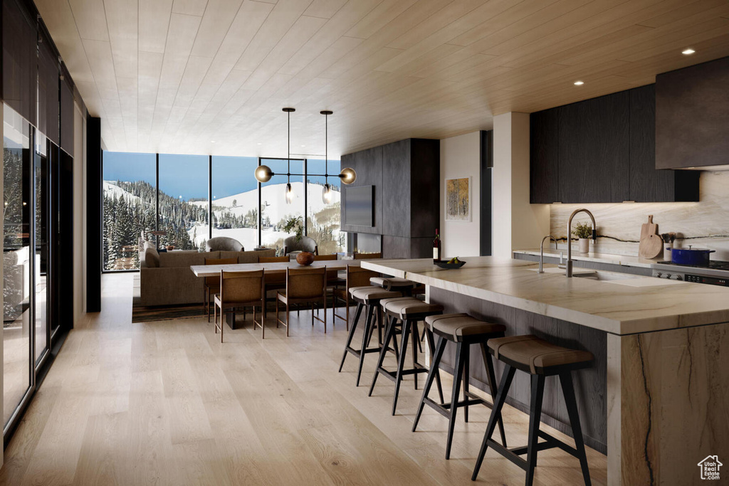 Kitchen with light hardwood / wood-style floors, a breakfast bar, a mountain view, wood ceiling, and a chandelier