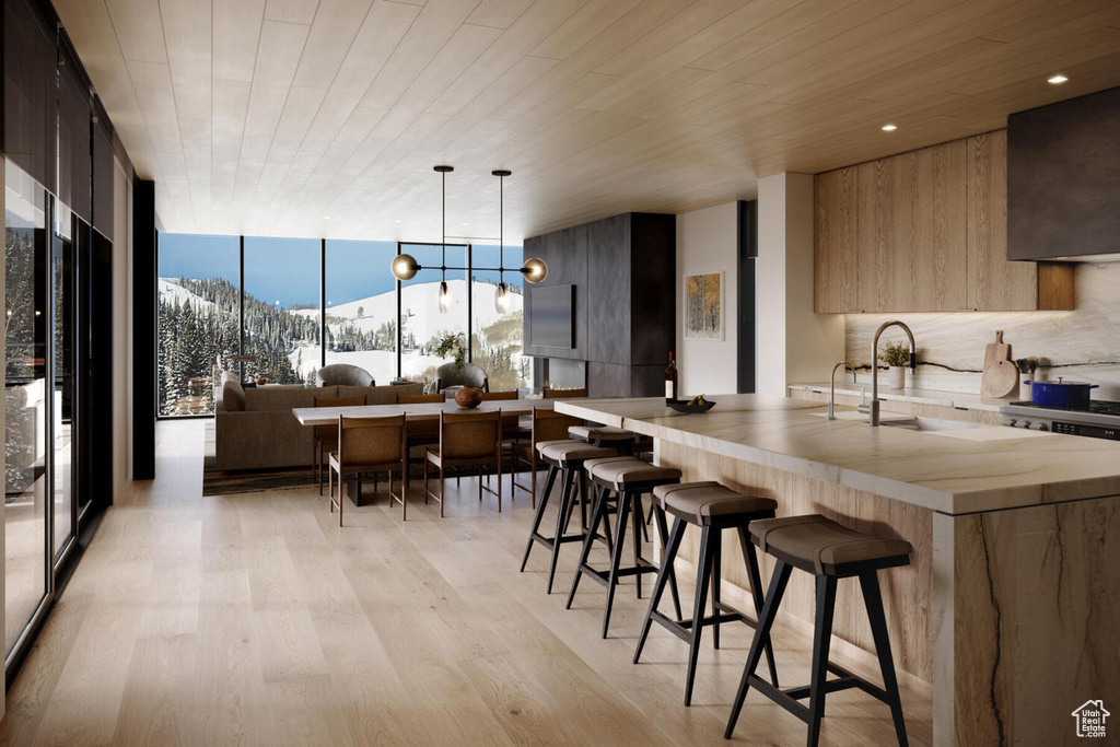 Kitchen with light wood-type flooring, a notable chandelier, a breakfast bar area, and a mountain view