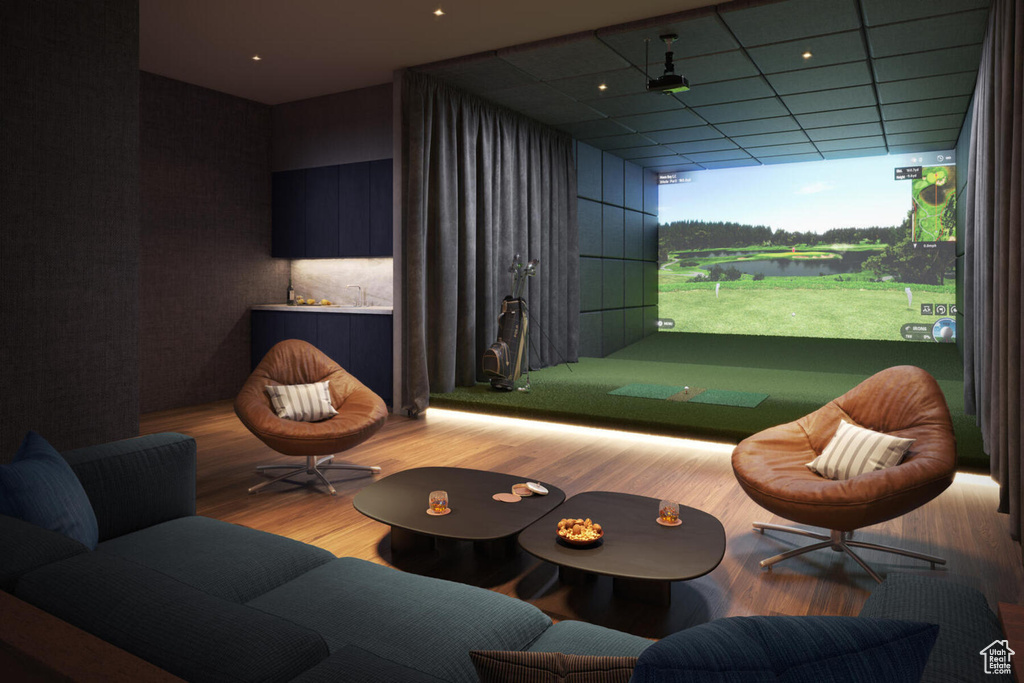 Recreation room featuring a water view, a paneled ceiling, light wood-type flooring, and golf simulator