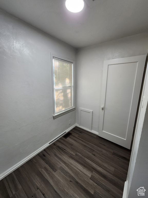 Empty room featuring dark wood-type flooring