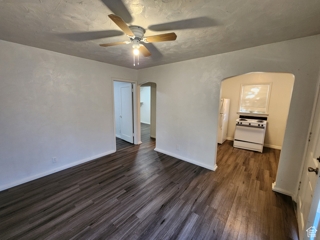 Unfurnished room featuring dark hardwood / wood-style flooring and ceiling fan