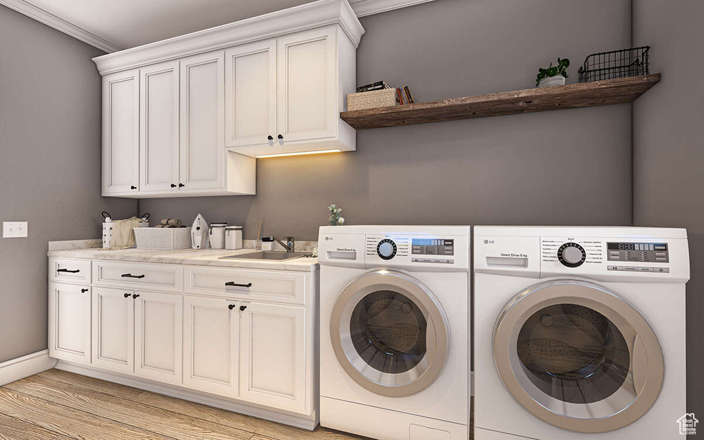 Laundry area with washing machine and clothes dryer, crown molding, cabinets, light wood-type flooring, and sink