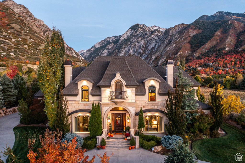French country home with french doors, a balcony, and a mountain view