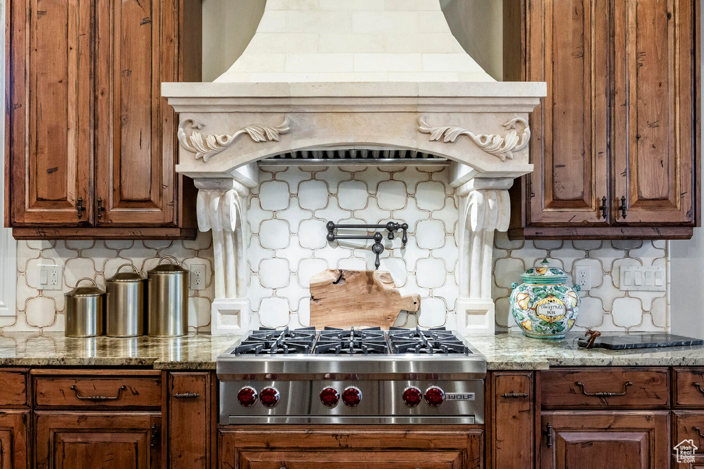 Kitchen featuring tasteful backsplash, stainless steel gas stovetop, and light stone counters