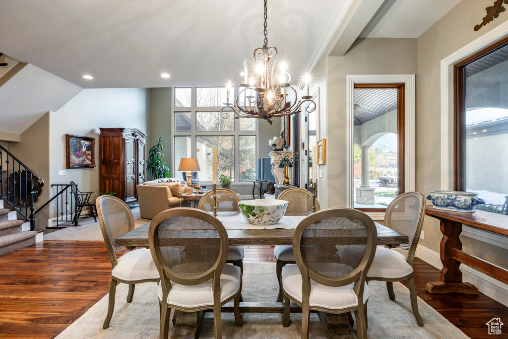 Dining area with an inviting chandelier, dark hardwood / wood-style flooring, and plenty of natural light