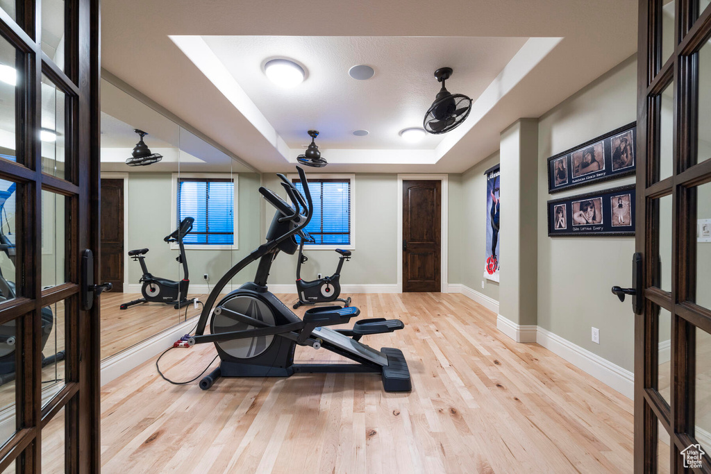 Workout area featuring light hardwood / wood-style flooring and a raised ceiling