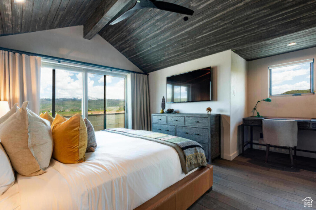 Bedroom featuring lofted ceiling with beams, multiple windows, dark hardwood / wood-style flooring, and ceiling fan