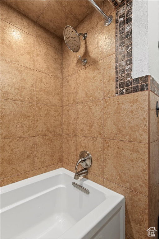 Bathroom featuring tile walls and tiled shower / bath combo