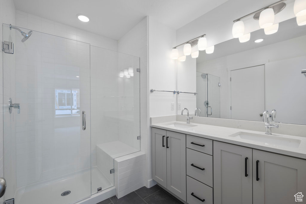Bathroom with oversized vanity, tile floors, double sink, and walk in shower