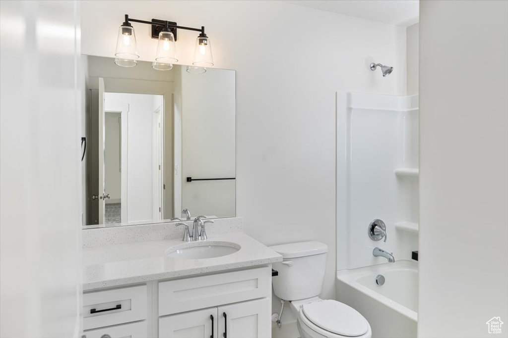 Full bathroom featuring  shower combination, toilet, and vanity with extensive cabinet space