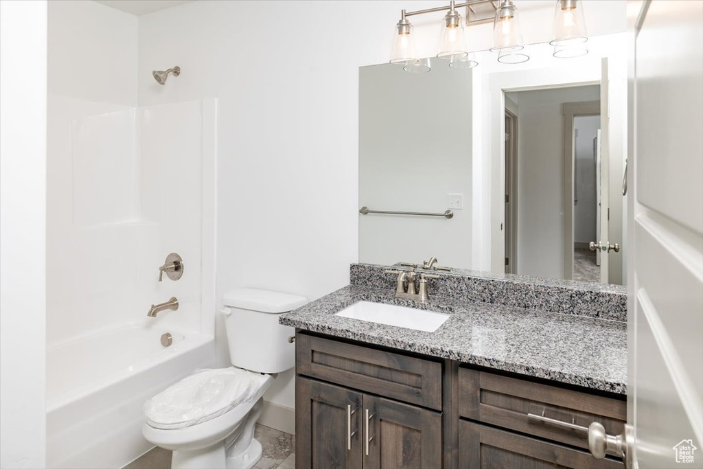 Full bathroom with vanity with extensive cabinet space, toilet, and shower / bath combination