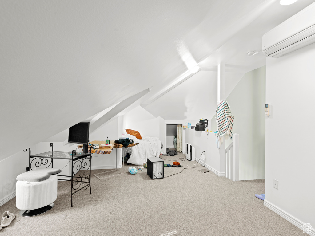 Office space featuring lofted ceiling, an AC wall unit, and light colored carpet