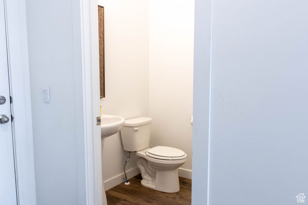 Bathroom with hardwood / wood-style floors, toilet, and sink