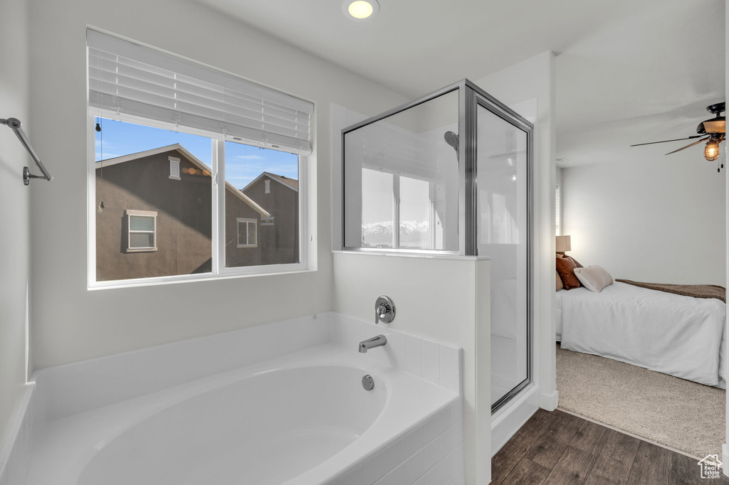 Bathroom with ceiling fan, plus walk in shower, and hardwood / wood-style floors
