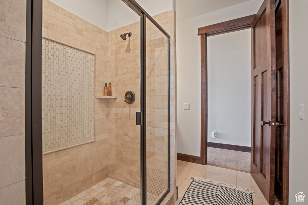 Bathroom featuring tile floors and a shower with door
