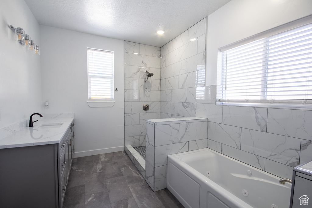 Bathroom with vanity, tile flooring, and independent shower and bath