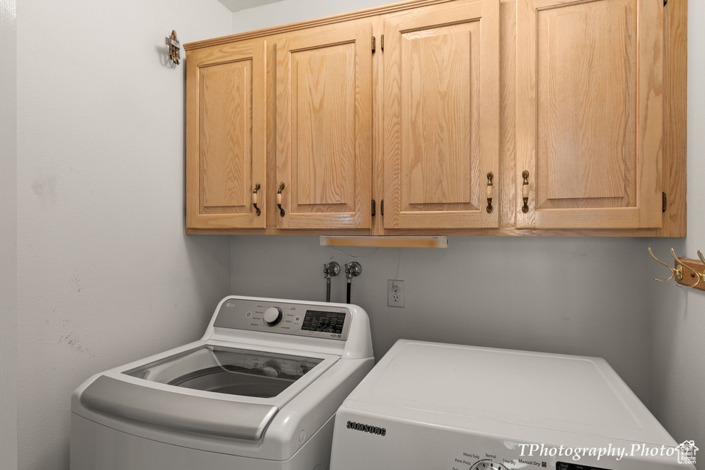 Laundry area with cabinets, washer and clothes dryer, and washer hookup