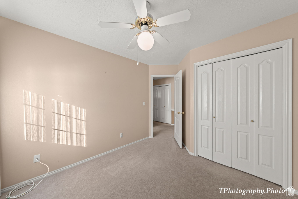 Unfurnished bedroom with a closet, light carpet, and ceiling fan
