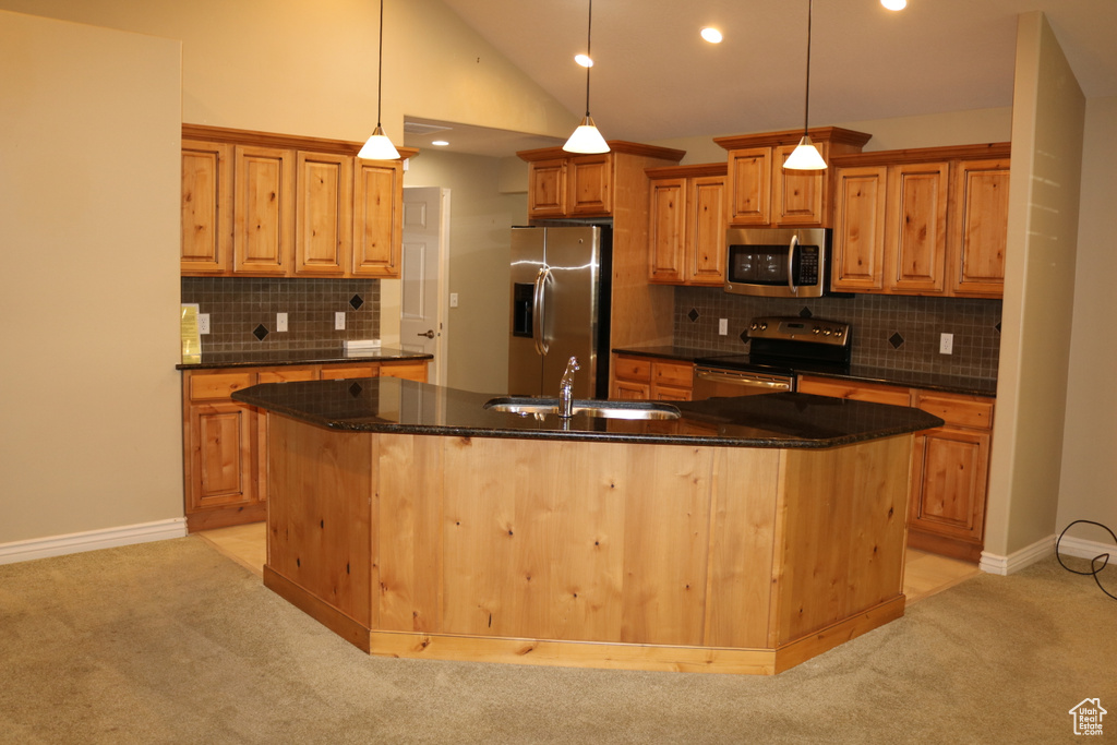 Kitchen featuring pendant lighting, a center island with sink, and appliances with stainless steel finishes