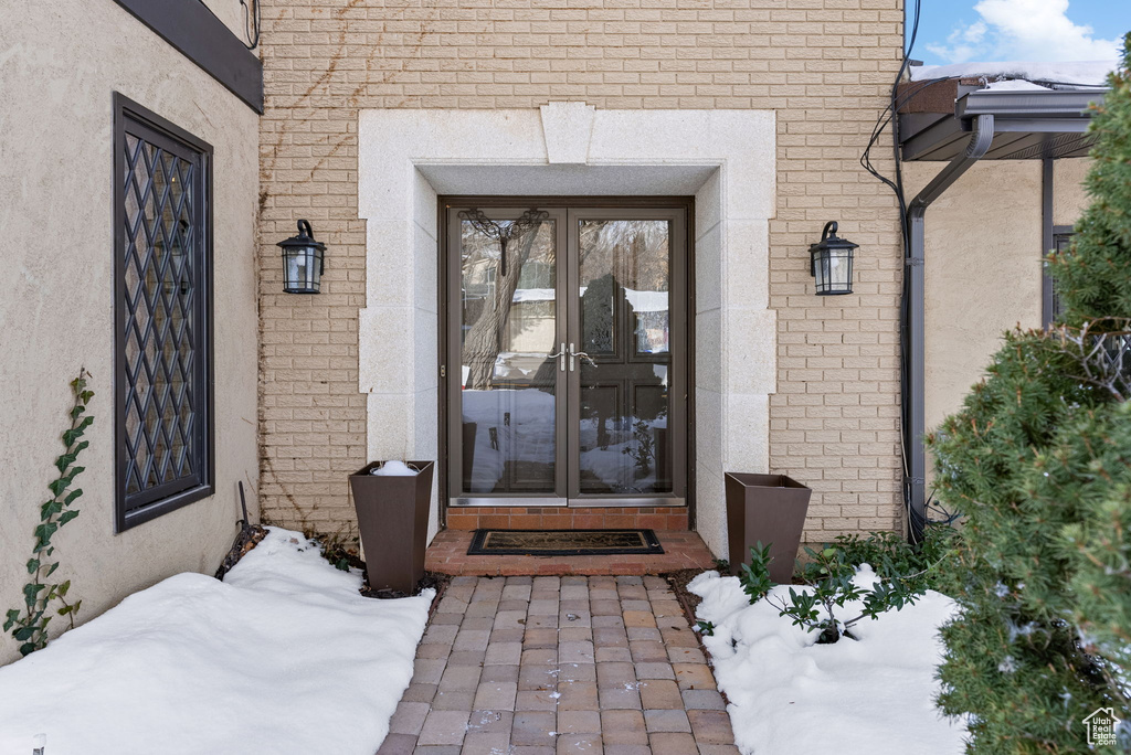 Snow covered property entrance with french doors