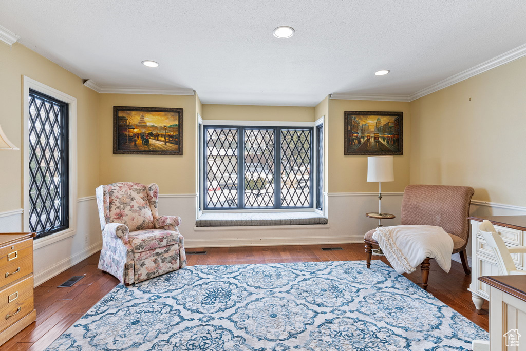 Sitting room featuring ornamental molding and dark hardwood / wood-style floors