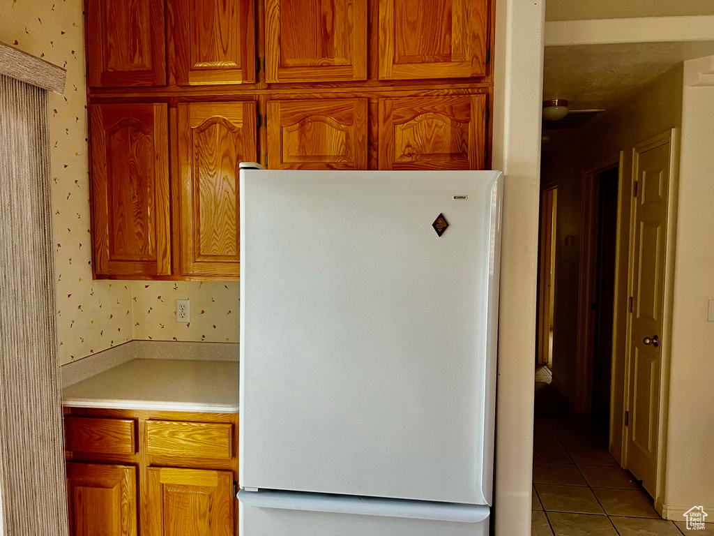 Kitchen with white fridge and light tile floors