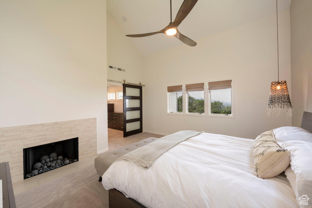 Bedroom with high vaulted ceiling, a fireplace, and ceiling fan