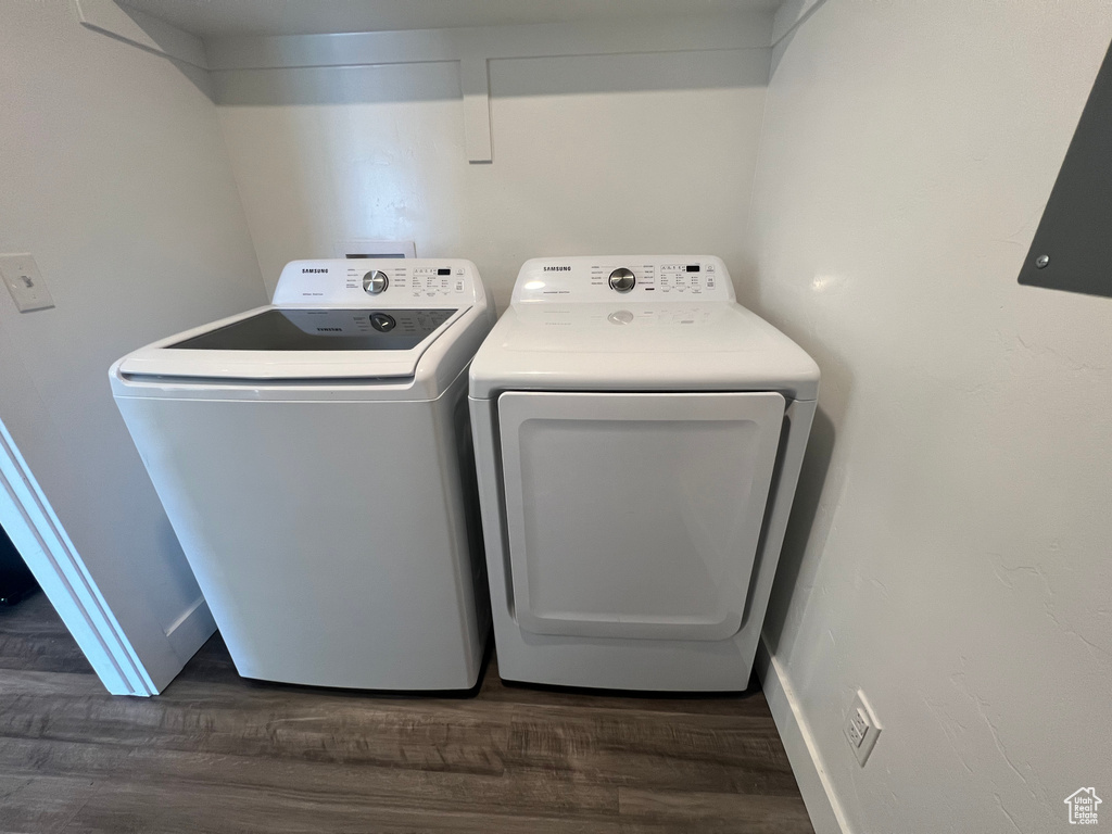 Laundry area with dark hardwood / wood-style flooring and washer and dryer