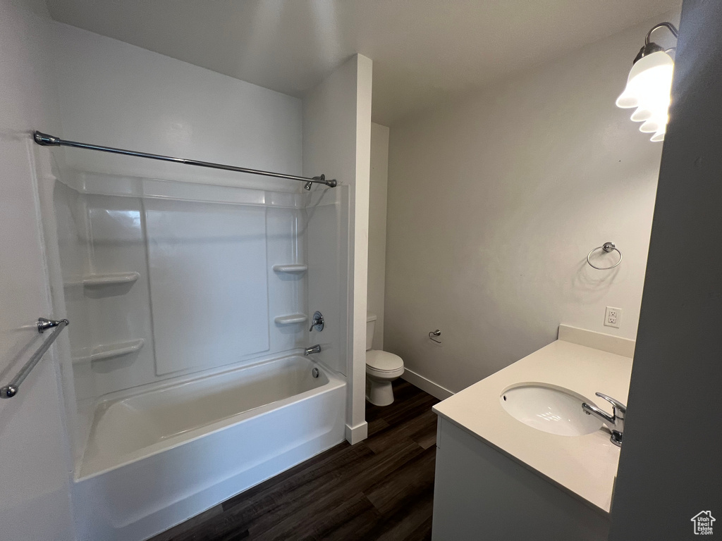 Full bathroom featuring vanity, toilet, bathing tub / shower combination, and hardwood / wood-style floors