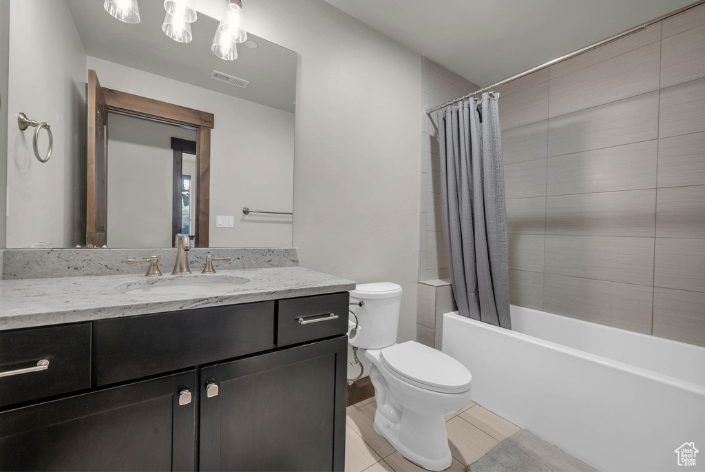 Full bathroom featuring vanity, shower / bath combination with curtain, tile flooring, and toilet