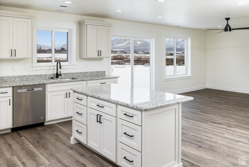 Kitchen featuring dishwasher, white cabinetry, and hardwood / wood-style flooring