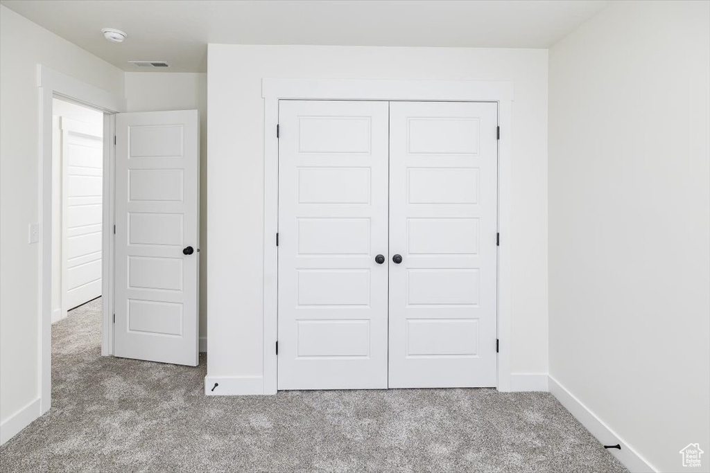 Unfurnished bedroom featuring carpet floors and a closet