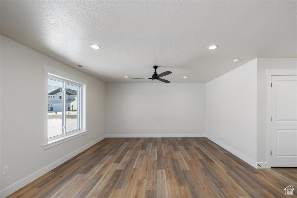 Unfurnished room with dark hardwood / wood-style floors, a textured ceiling, and ceiling fan
