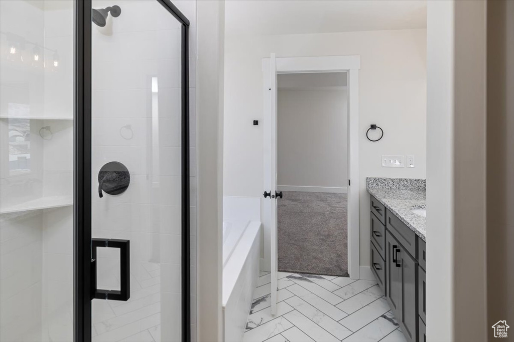 Bathroom with tile floors, independent shower and bath, and vanity