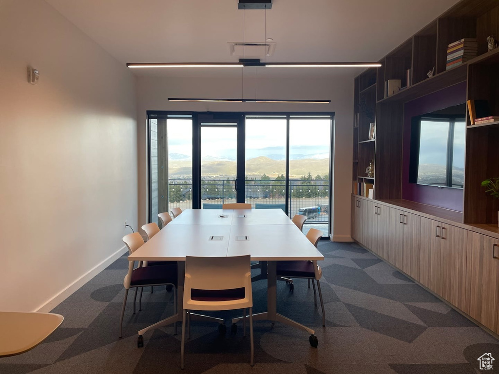 Carpeted dining area featuring a wealth of natural light and a mountain view