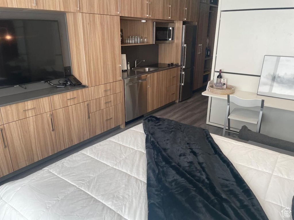 Bedroom with dark wood-type flooring, sink, and high end refrigerator