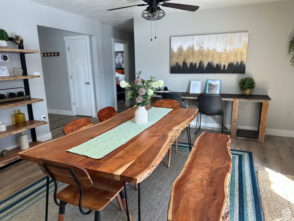 Dining room featuring dark hardwood / wood-style flooring, a textured ceiling, and ceiling fan