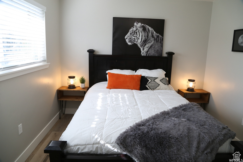 Bedroom with multiple windows and dark hardwood / wood-style flooring