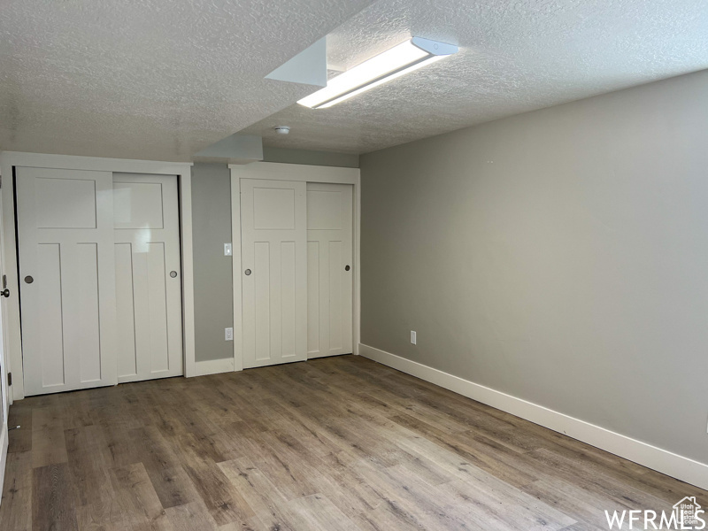 Unfurnished bedroom with a textured ceiling and hardwood / wood-style flooring