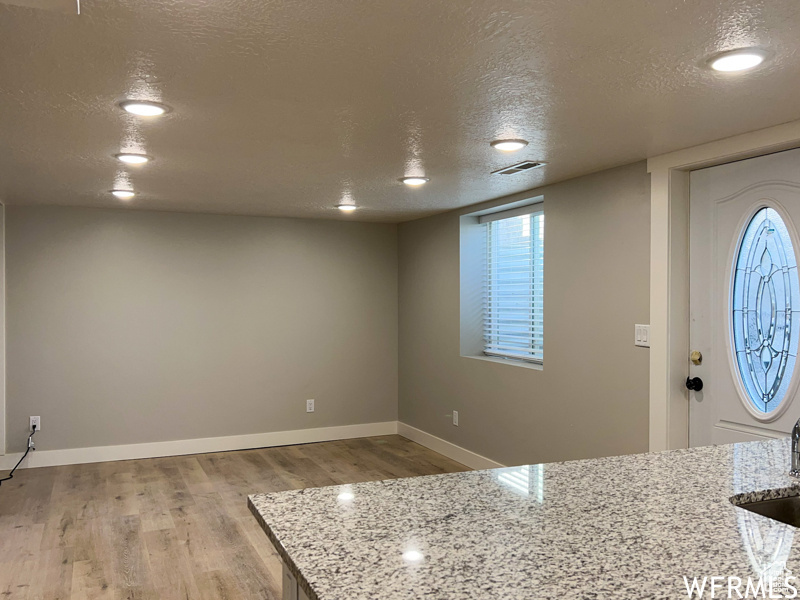 Entryway with wood-type flooring and a textured ceiling