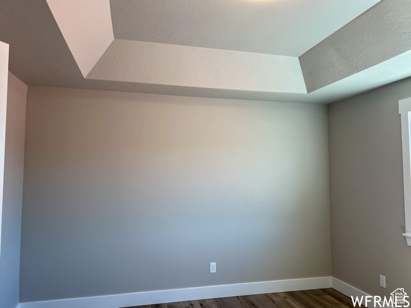 Empty room with dark wood-type flooring